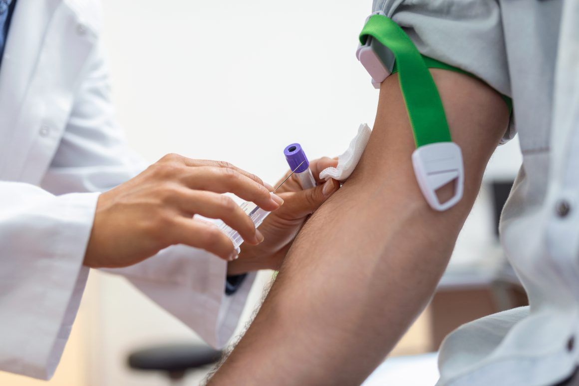 Preparation for blood test by female doctor medical uniform on the table in white bright room. Nurse pierces the patient's arm vein with needle blank tube. Analisis Clínicos